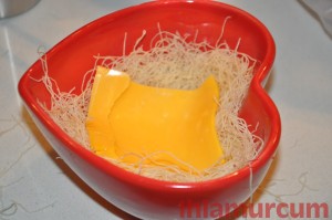 Kalp bir kaseye biraz kadayıf yayıp,iyice kadayıfı bastırın.Yaydığınız kadayıfın üzerine 1 dilim peyniri yerleştirin.